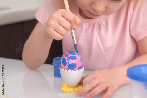 Happy easter. Little girl painting Easter eggs. Happy family children preparing for Easter. Cute little child girl wearing bunny ears on Easter day. Close up