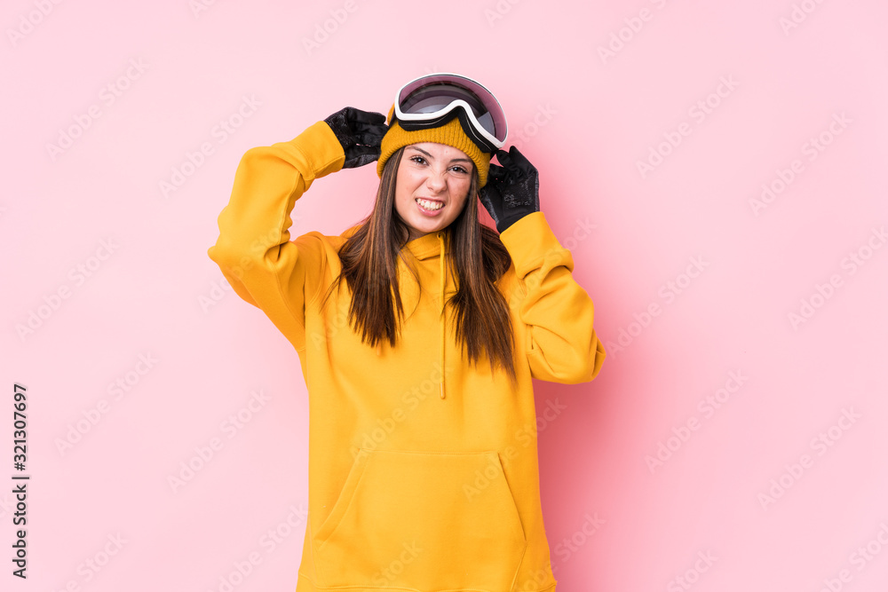 Young caucasian skier woman isolated covering ears with hands.
