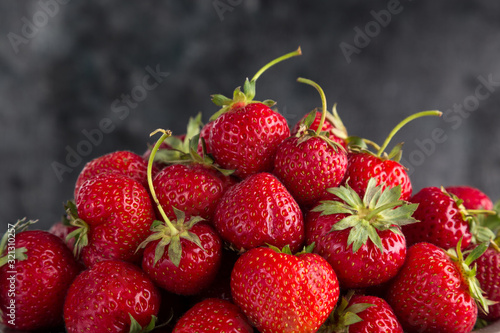 Fresh juicy strawberries from the garden in an iron bowl on the table. Heap of fresh strawberries in an iron bowl on rustic white wooden background. Fresh organic berries macro. Free space for text.