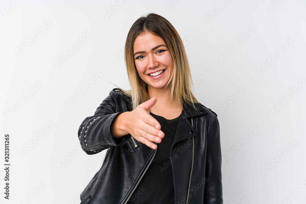 Young caucasian woman wearing a black leather jacket stretching hand at camera in greeting gesture. Young caucasian woman wearing a black leather jacket stretching hand at camera in greeting gesture.