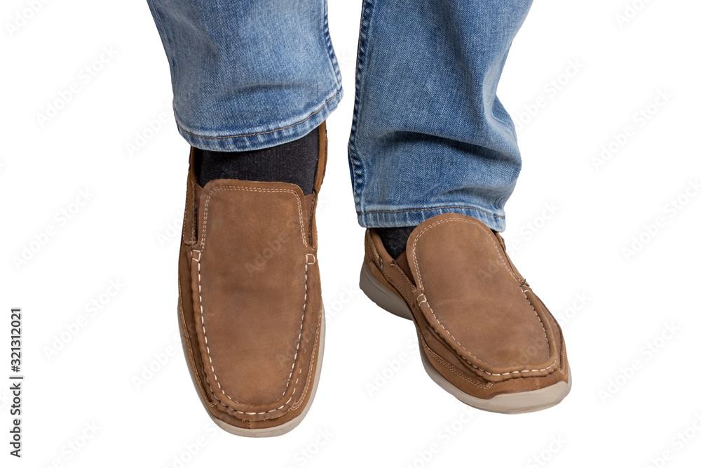 Male legs in jeans and fashionable stylish brown shoes or mocassins isolated on a white background. Macro photograph.