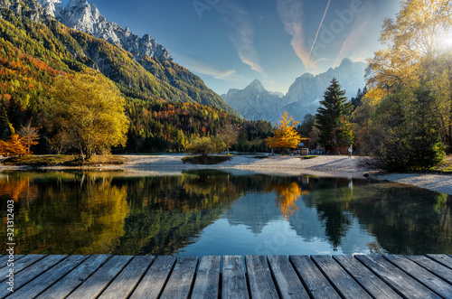 Amazing nature Landscape in Julian Alps during sunset. Lake Jasna near Kranjska Gora, Slovenia. Crystal clear alpine with colorful trees and mountain peaks in background. Triglav national park