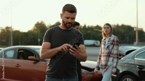 Confused middle-aged man in trouble using a smartphone outdoors. Male driver upset with the situation. Car crash. Police in action. © Fractal Pictures
