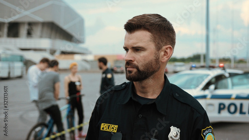 Konstfotografi Attractive serious police officer finding illegal drugs talking walkie-talkie with colleagues staying at crime scene area outdoors