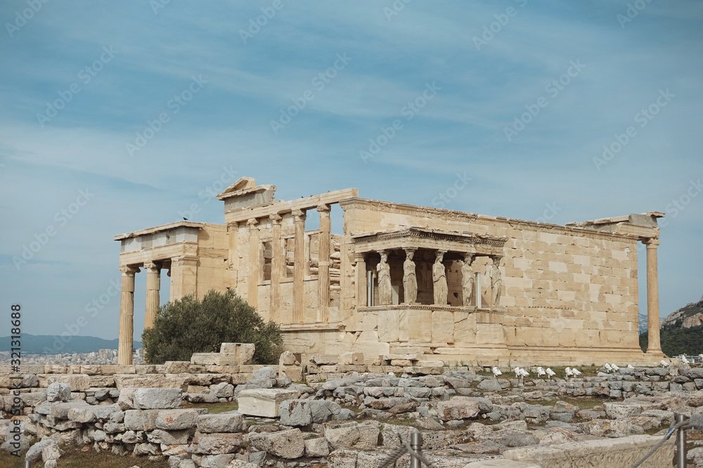 Erechtheion temple with Caryatid Porch on the Acropolis, Athens, Greece. Famous old Acropolis hill is top landmark of Athens. Ancient Greek ruins in Athens center. Remains of antique Athens in summer.