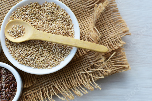 Quinoa, chia and linseed seeds on light wood background