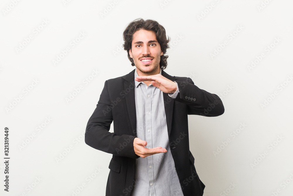 Young business man against a white background holding something with both hands, product presentation. Young business man against a white background holding something with both hands, product presentation.
