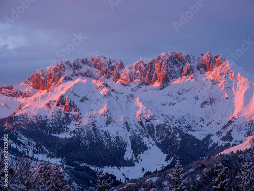 Presolana is a mountain range of the Orobie, Italian Alps. Landscape in winter. At sunset the rocks become red, orange and pink