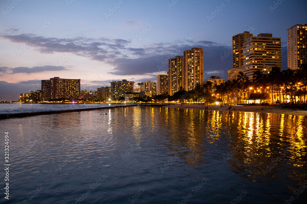 Waikiki skyline at night with water reflection