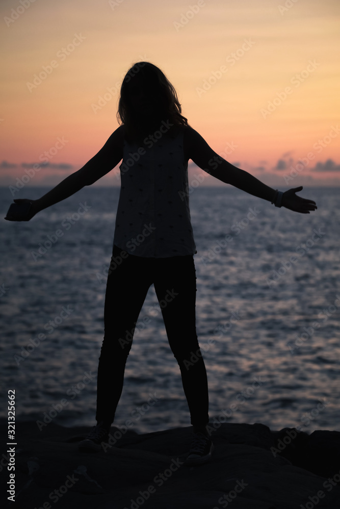 Vertical silhouette photo of happy girl on a beach