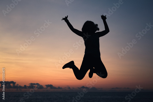 Silhouette photo of a girl jumping over sky