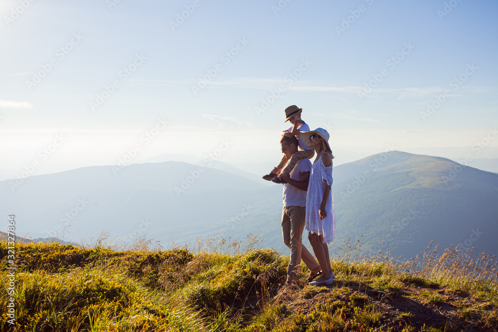 Fototapeta premium The family admires the mountain landscape during walking
