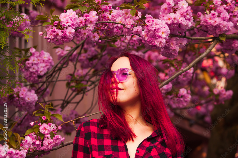 Female model with brightful hair color on sakura blossom background Female model with brightful hair color on sakura blossom background