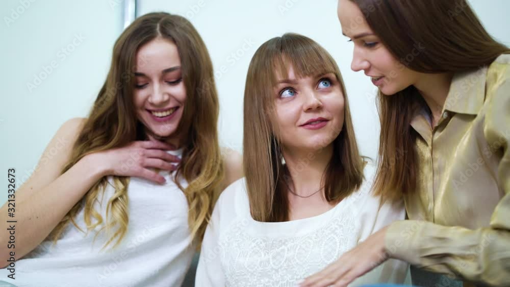 Three pretty girls watching fashion catalog in salon Three pretty girls watching fashion catalog in salon
