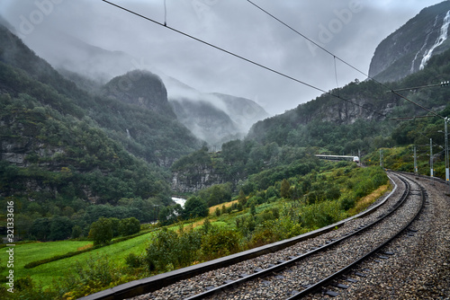 Escena con niebla en los montes de Noruega en la que se ve una via de tren.