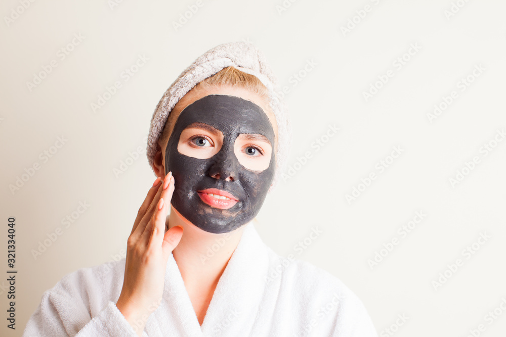 Young beautiful woman in a mask for the face of the therapeutic black mud Young beautiful woman in a mask for the face of the therapeutic black mud