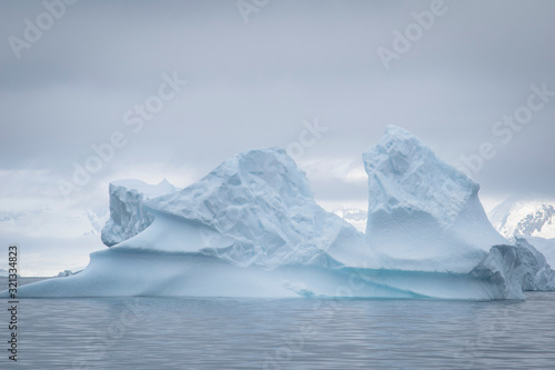 Antarctic icebergs and majestic landscape, cloudy blue sky