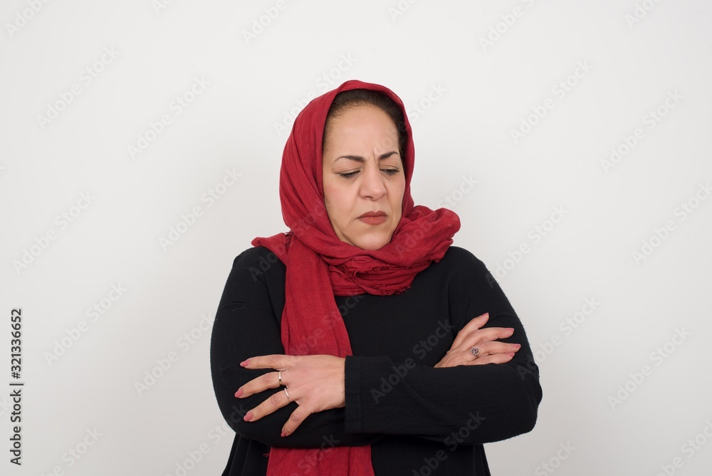 Closeup portrait displeased pissed off angry grumpy muslim woman with bad attitude, arms crossed looking sideways. Negative human emotion facial expression feelings Closeup portrait displeased pissed off angry grumpy muslim woman with bad attitude, arms crossed looking sideways. Negative human emotion facial expression feelings