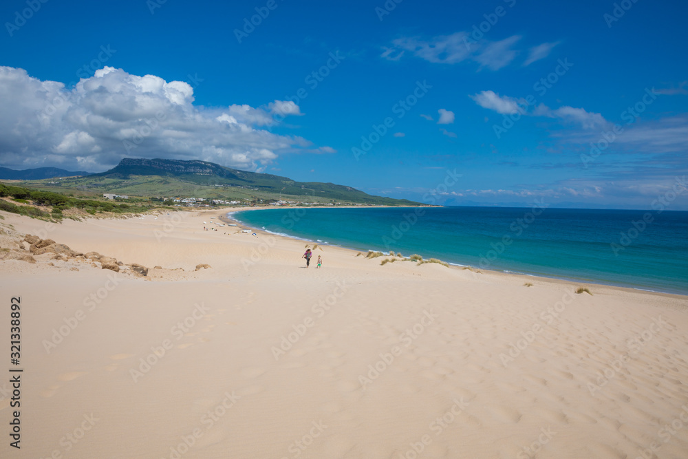 beautiful landscape of wild natural Beach Bolonia in Tarifa, Cadiz, Andalusia, Spain, with woman and little girl walking. Copy or text space