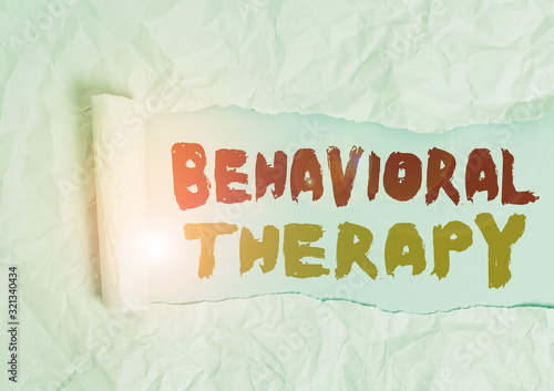 Word writing text Behavioral Therapy. Business photo showcasing help change potentially selfdestructive behaviors Cardboard which is torn in the middle placed above a plain table backdrop photo