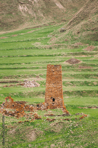 Ancient Old Stone Watchtower On Mountain Background In Chetoyta Or Zakagori Village, Kazbegi District, Mtskheta-Mtianeti Region, Georgia. Spring, Summer Season. Truso Gorge. photo