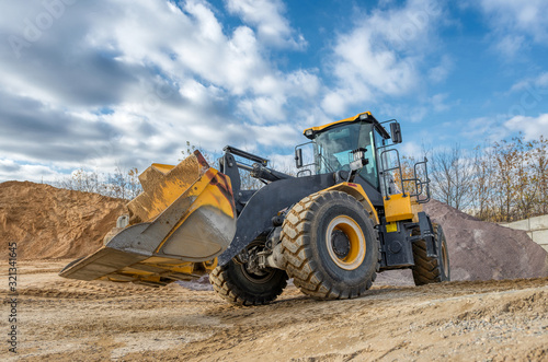 A wheel loader travels through a sand and gravel warehouse.