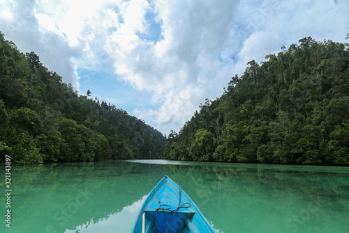 POV on the kayak on the Green river through the dense jungle inthe frorest of Raja Ampat, West Papua province, Indonesia photo