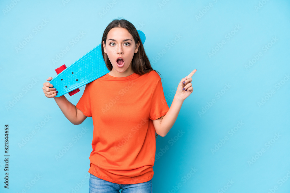 Young caucasian skater woman isolated pointing to the side Young caucasian skater woman isolated pointing to the side