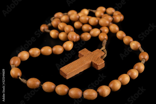 Wooden rosary arranged on the table. Prayer accessories.