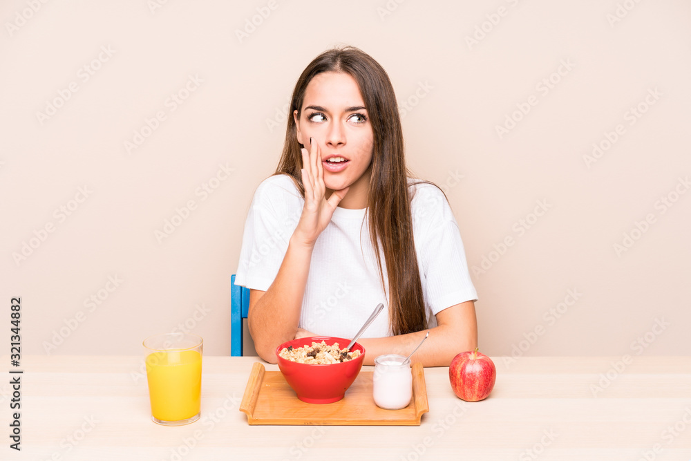 Young caucasian woman having a breakfast isolated is saying a secret hot braking news and looking aside Young caucasian woman having a breakfast isolated is saying a secret hot braking news and looking aside