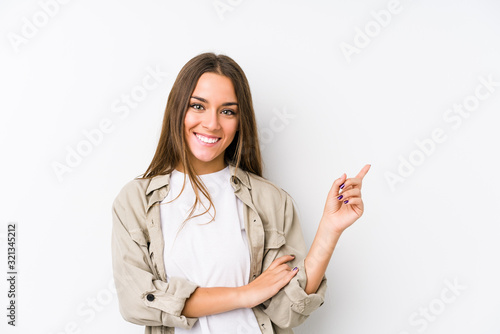 Young caucasian woman  isolated smiling cheerfully pointing with forefinger away.