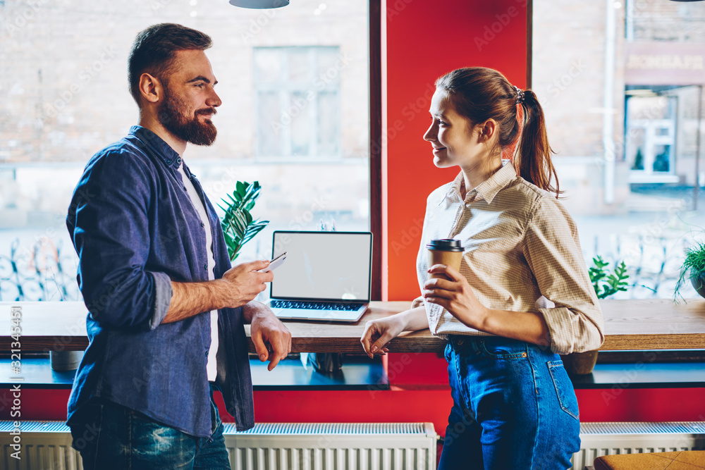 Obraz premium Cheerful freelancers talking during break in cafe