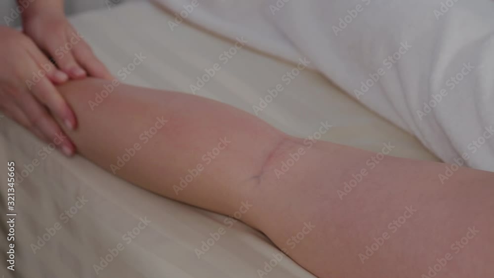 Female massage therapist massaging client's legs. Female massage therapist massaging client's legs.