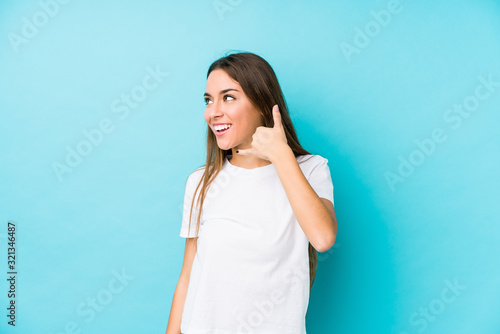 Young caucasian woman isolated showing a mobile phone call gesture with fingers.