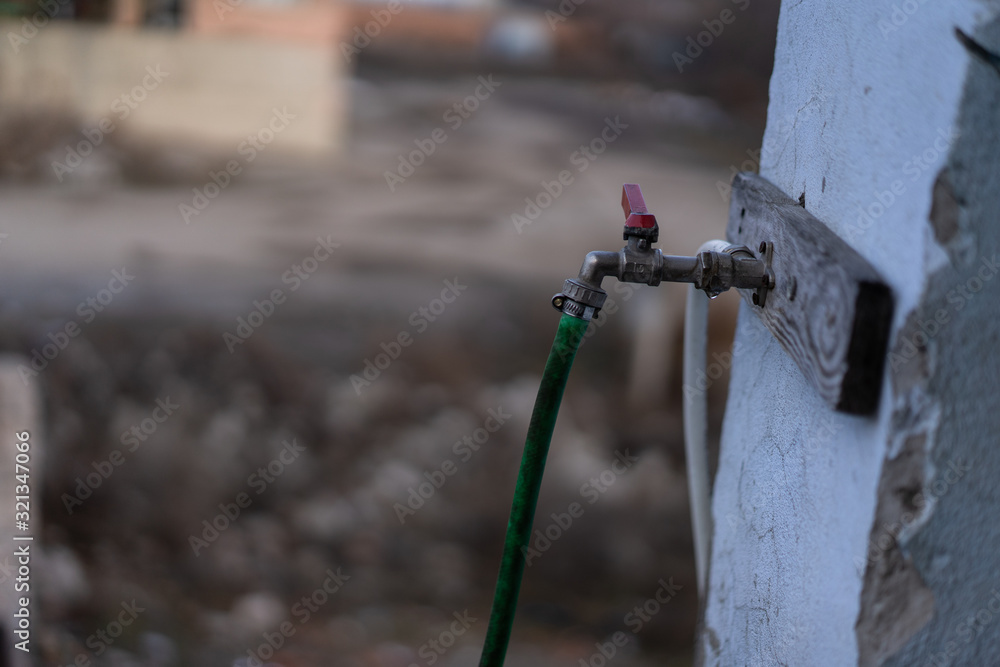 Naklejka premium Water faucet with a hose connected to a metal screed