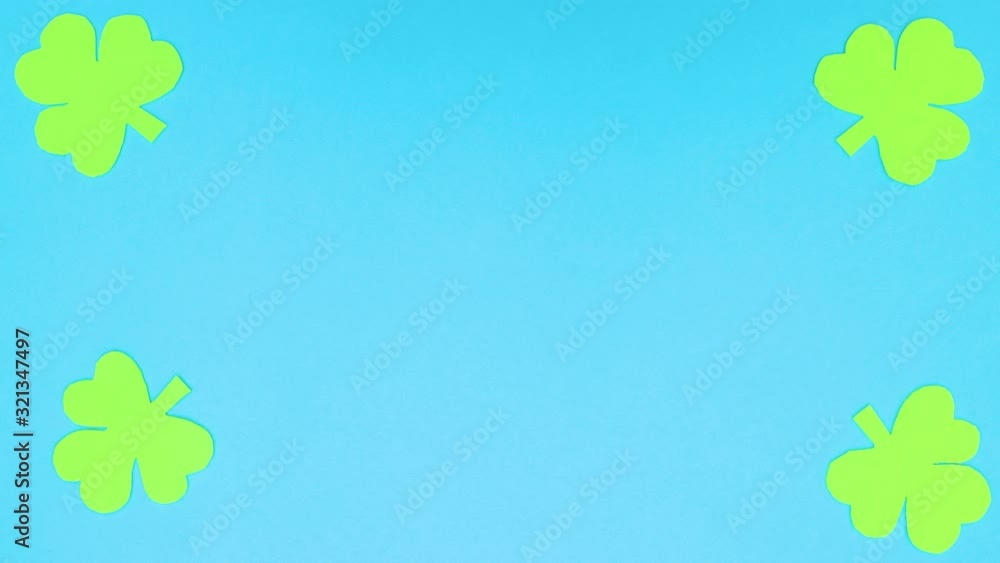 Clovers moving on the edges of blue background - Stop motion Clovers moving on the edges of blue background - Stop motion