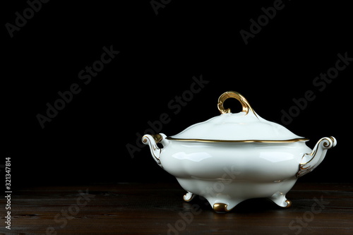 Εκτύπωση καμβά porcelain tureen with gilding on a dark wooden table with copy space