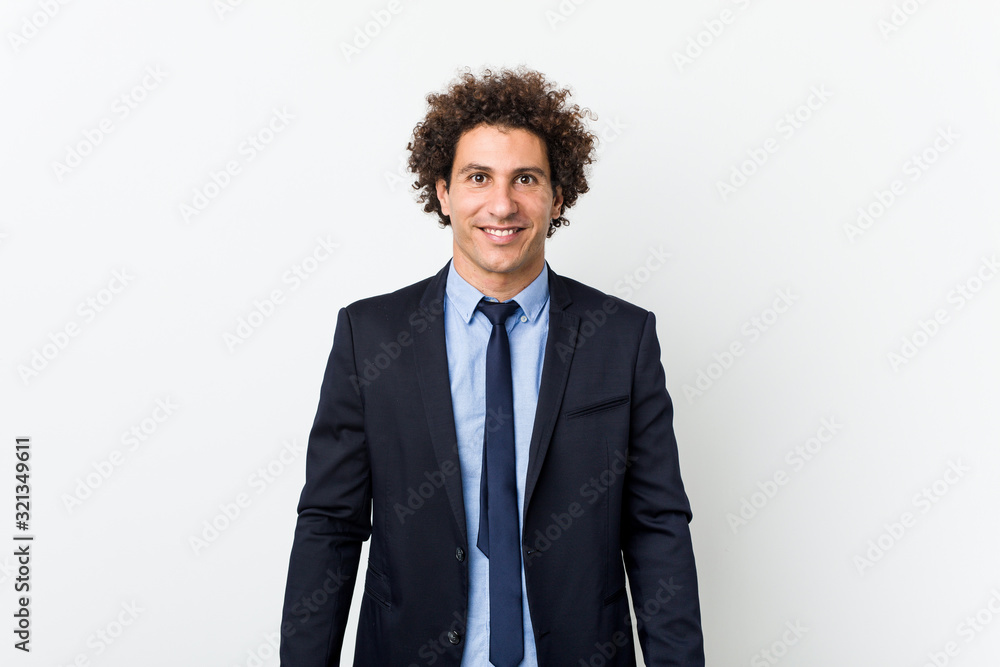 Young business curly man against white background happy, smiling and cheerful. Young business curly man against white background happy, smiling and cheerful.