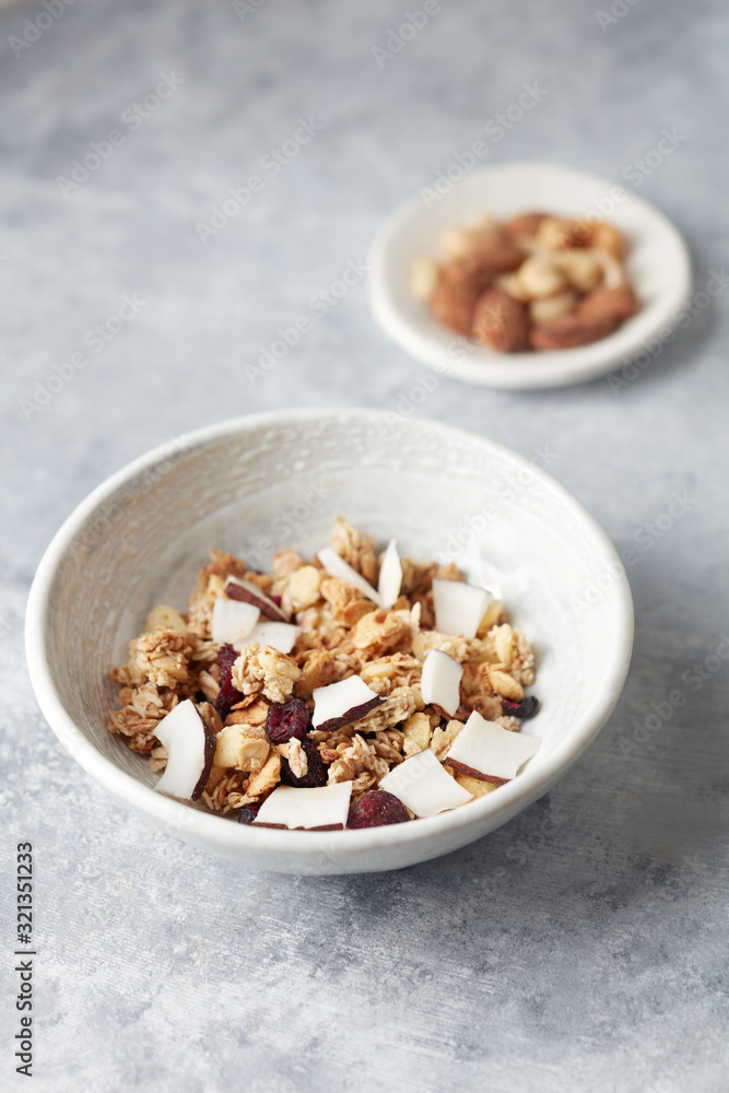 Bowl of granola with nuts, cranberry and cocoanut. Concept for a tasty and healthy meal. Stone background. Copy space. Bowl of granola with nuts, cranberry and cocoanut. Concept for a tasty and healthy meal. Stone background. Copy space.