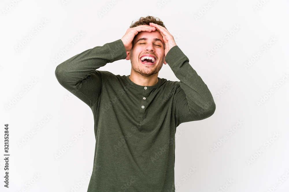 Young blond curly hair caucasian man isolated laughs joyfully keeping hands on head. Happiness concept. Young blond curly hair caucasian man isolated laughs joyfully keeping hands on head. Happiness concept.