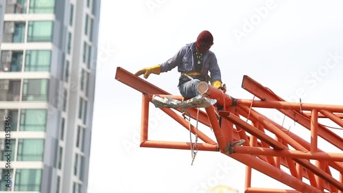The welding workers at structures site. Worker is welding steel structures. Workers are also working at high altitude with a set of fall protection devices.
