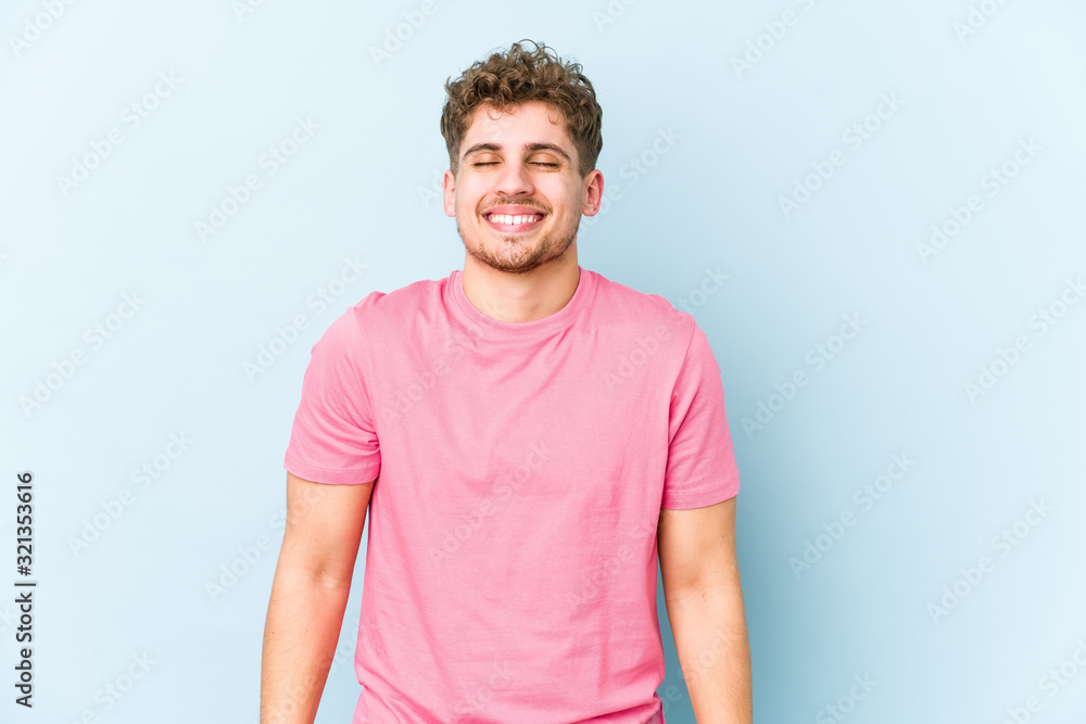 Obraz premium Young blond curly hair caucasian man isolated laughs and closes eyes, feels relaxed and happy.