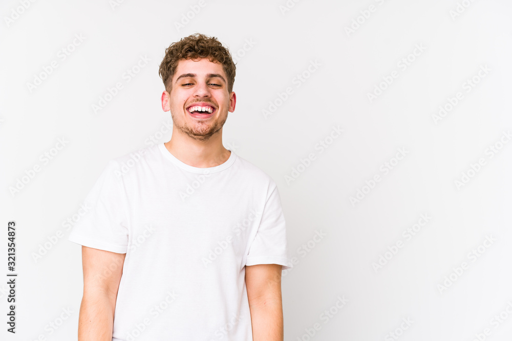Young blond curly hair caucasian man isolated laughing happy, carefree, natural emotion. Young blond curly hair caucasian man isolated laughing happy, carefree, natural emotion.