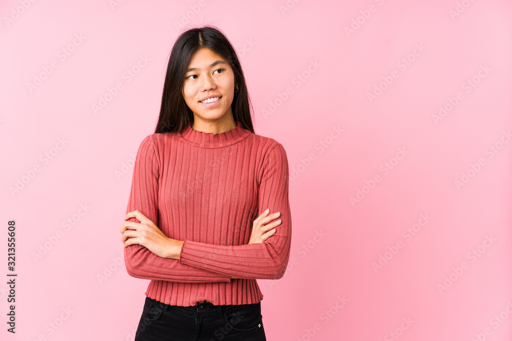 Fototapeta premium Young chinese woman posing isolated smiling confident with crossed arms.
