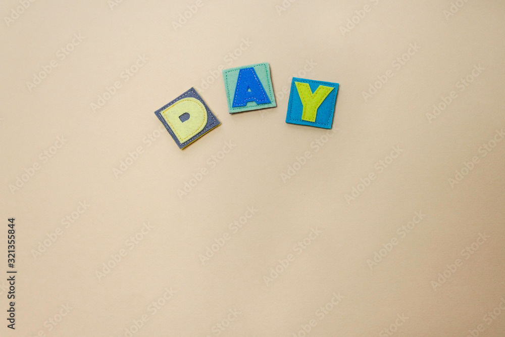 The word DAY. Hands of the child hold letters. Alphabet. Learn letters with a child. ABC The word DAY. Hands of the child hold letters. Alphabet. Learn letters with a child. ABC