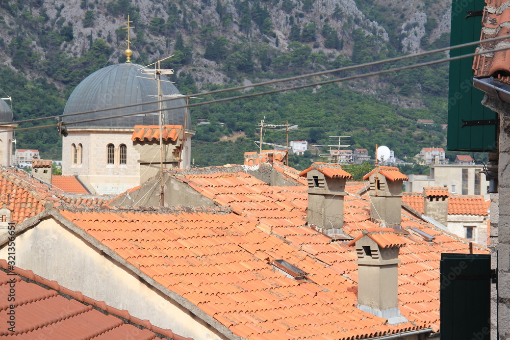 Obraz premium red roofs of old houses on a background of beautiful mountains