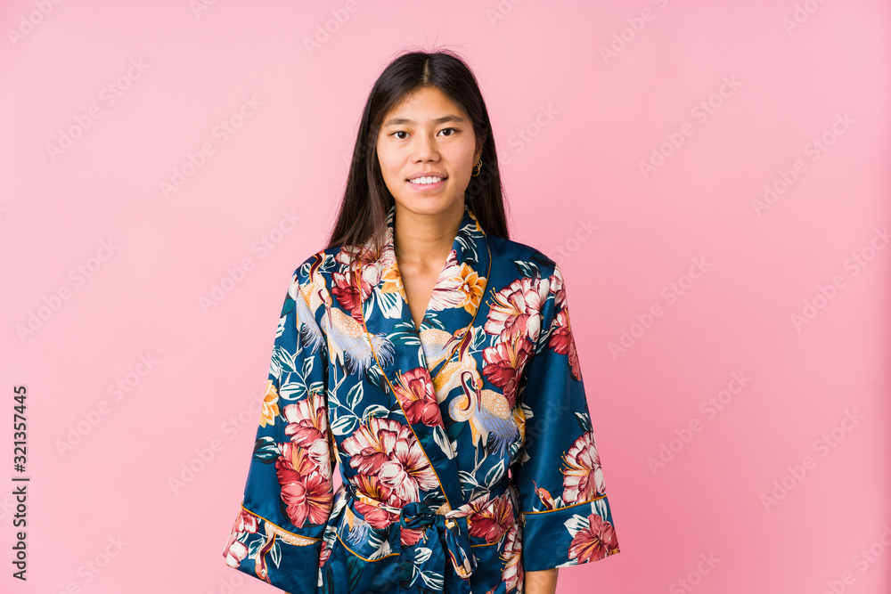 Young asian woman wearing a kimono pajamas happy, smiling and cheerful. Young asian woman wearing a kimono pajamas happy, smiling and cheerful.