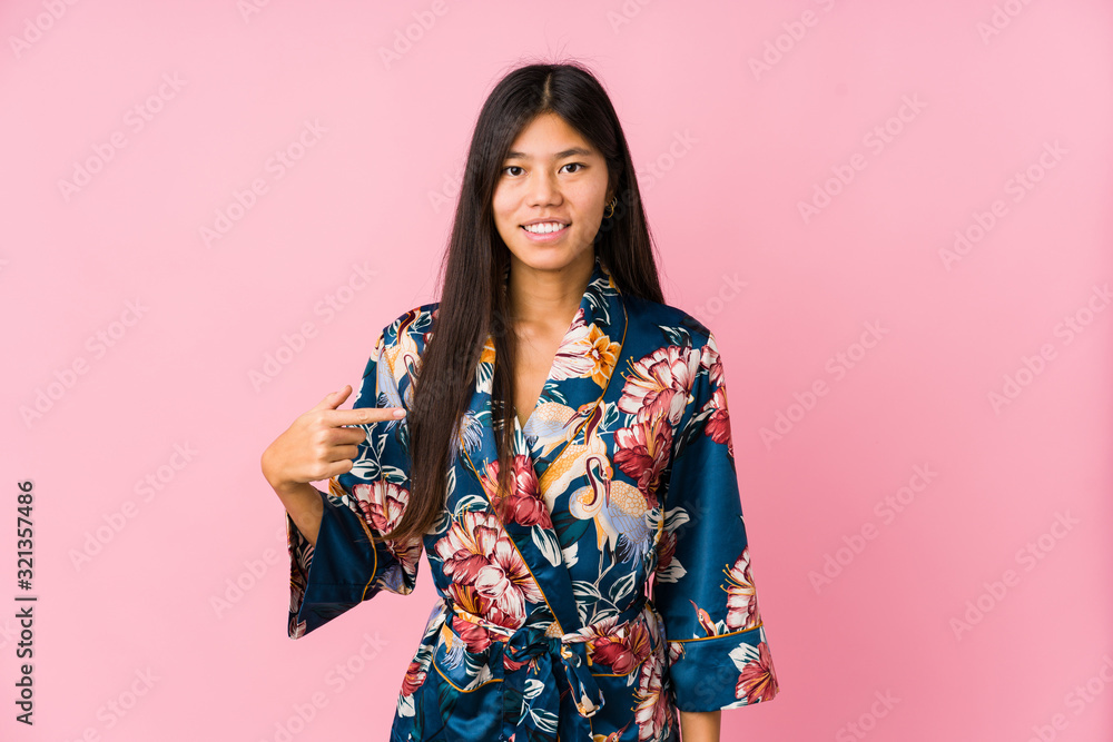 Young asian woman wearing a kimono pajamas person pointing by hand to a shirt copy space, proud and confident Young asian woman wearing a kimono pajamas person pointing by hand to a shirt copy space, proud and confident