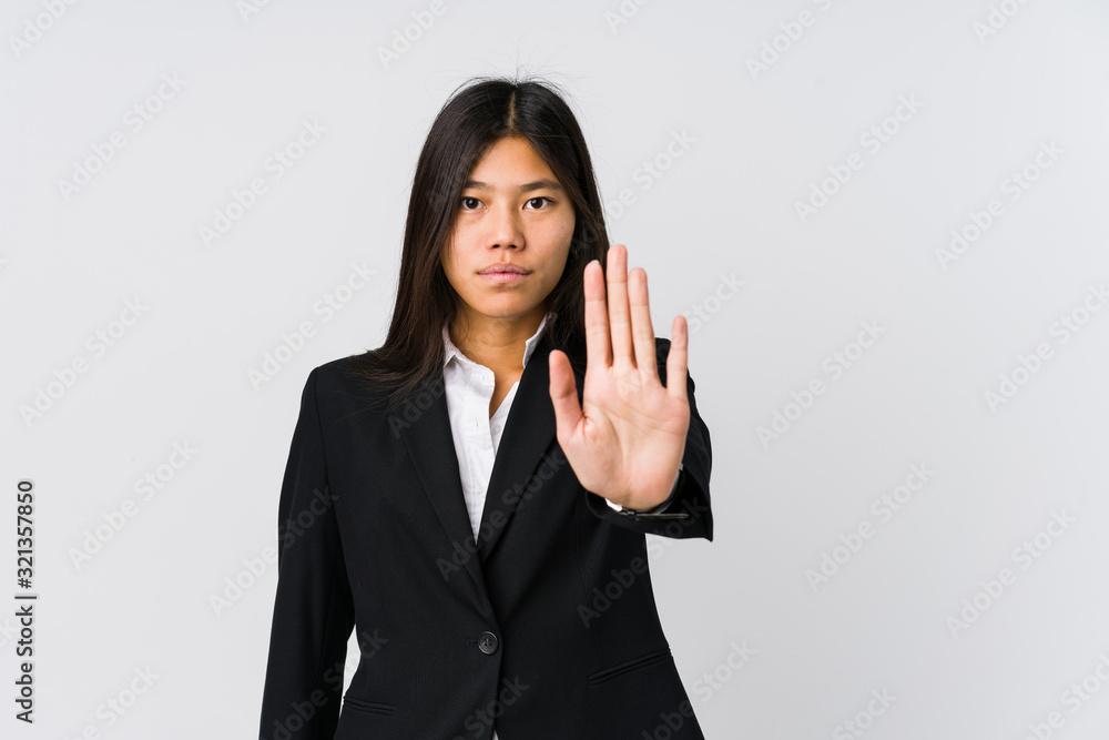 Young asian business woman standing with outstretched hand showing stop sign, preventing you. Young asian business woman standing with outstretched hand showing stop sign, preventing you.