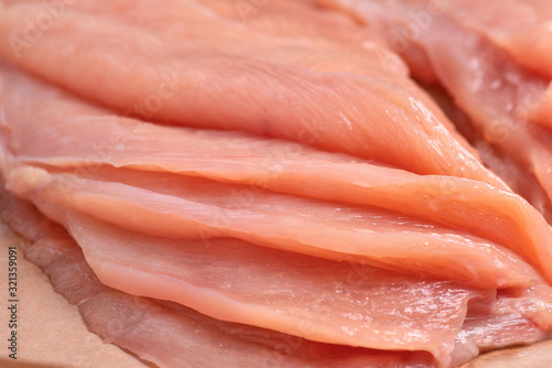 Raw sliced chicken meat close-up.Close-up view of raw, fresh, choped and sliced chicken meat. Sottilissime. Delicious dietary meat. Cooking. photo